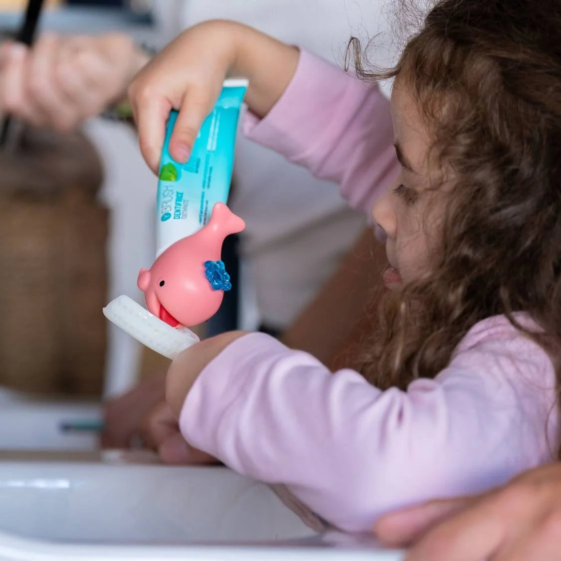 Child using a whale-shaped toothpaste with toothbrush